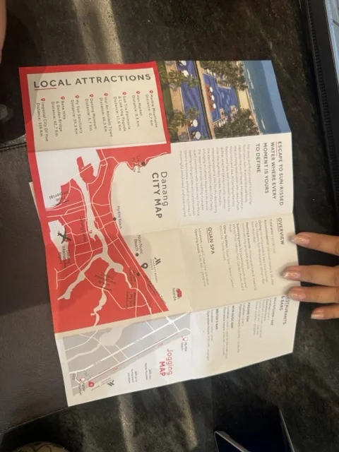 Paper hotel brochure showing Da Nang city map and local attractions — generic printed information that fails to deliver the personalized hotel experience AI could provide